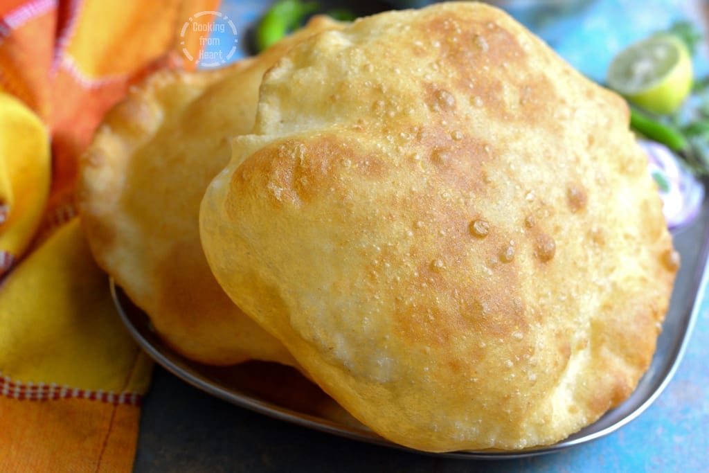 Golden, puffed puris served on a plate.