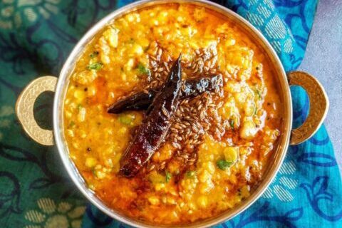 A bowl of spicy Indian dal garnished with dried red chilies.