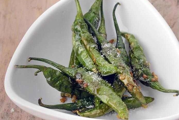 A plate of roasted green chili peppers sprinkled with salt.