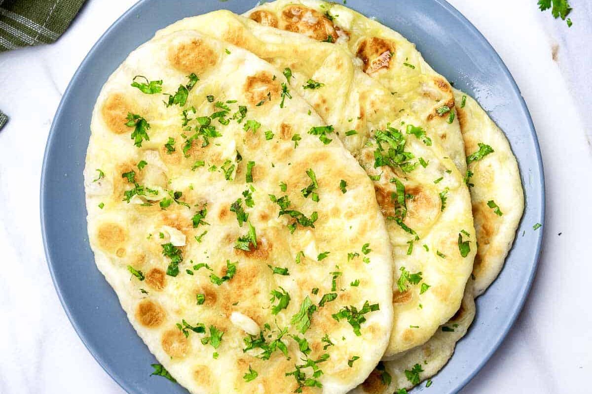 Plate of naan bread garnished with herbs.