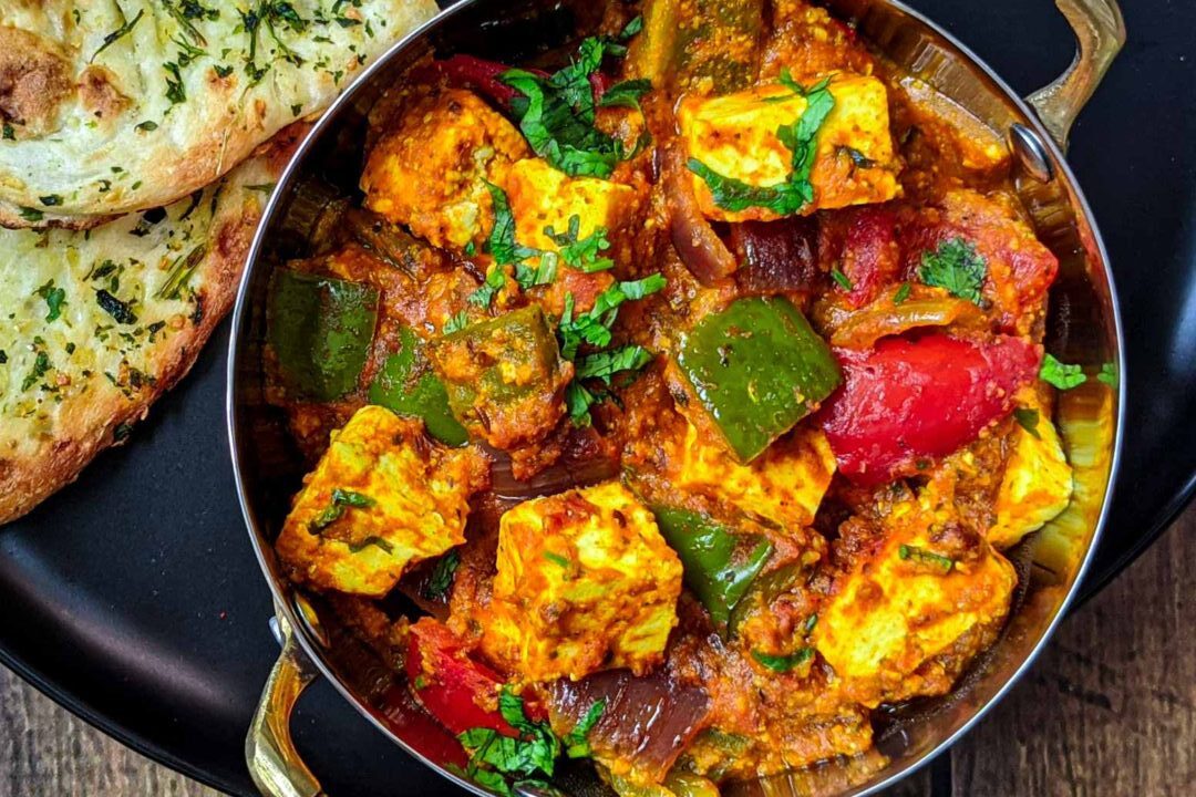 A vibrant chicken curry with colorful bell peppers and fresh herbs.