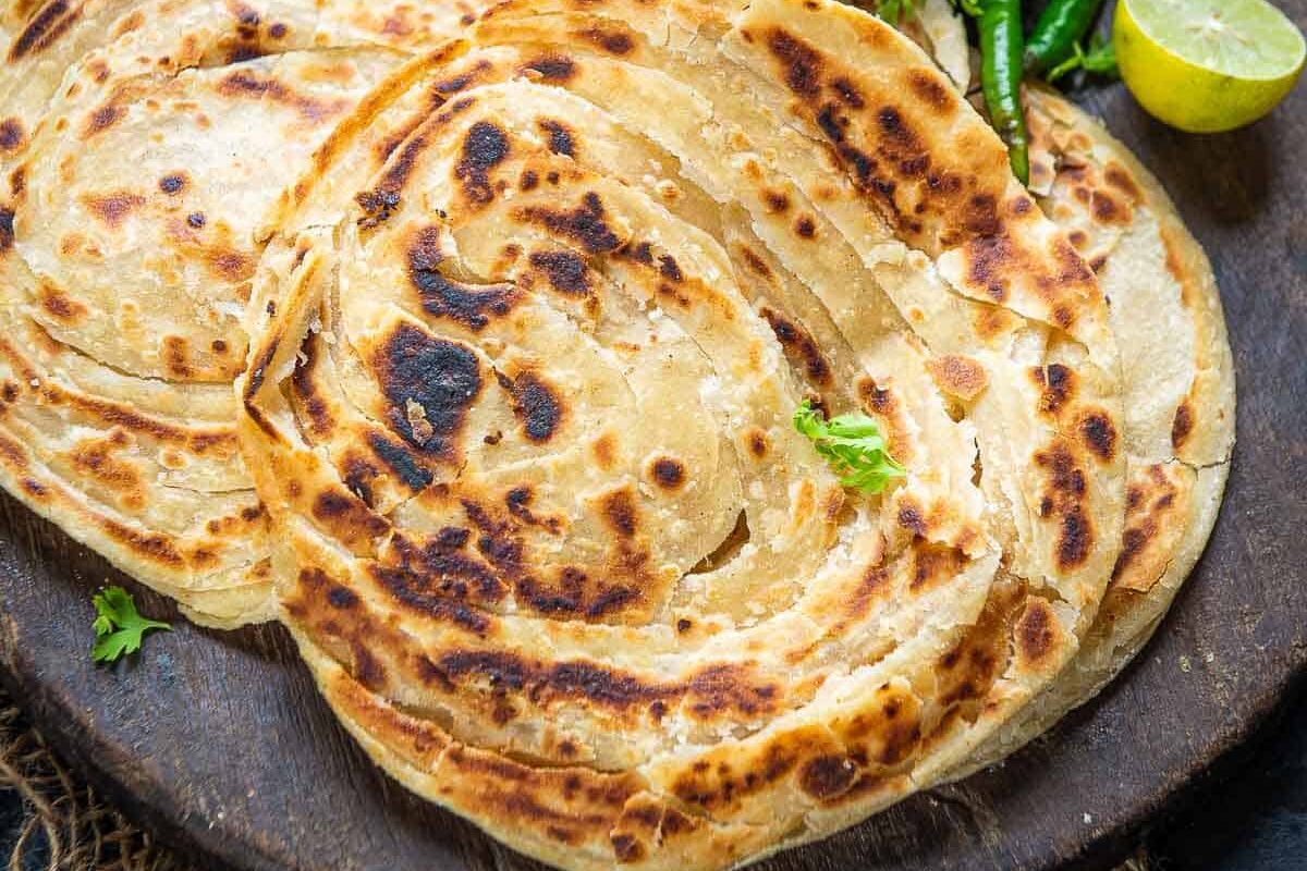 Close-up of a flaky, golden-brown paratha flatbread.