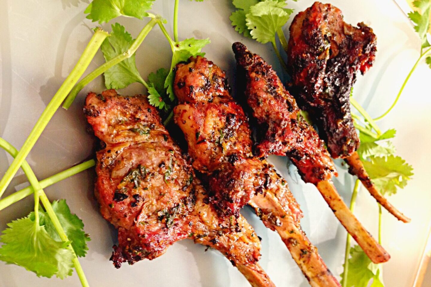 Grilled chicken drumsticks garnished with fresh herbs.