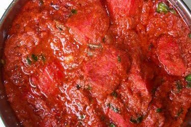 Close-up of a rich, herb-infused tomato sauce.