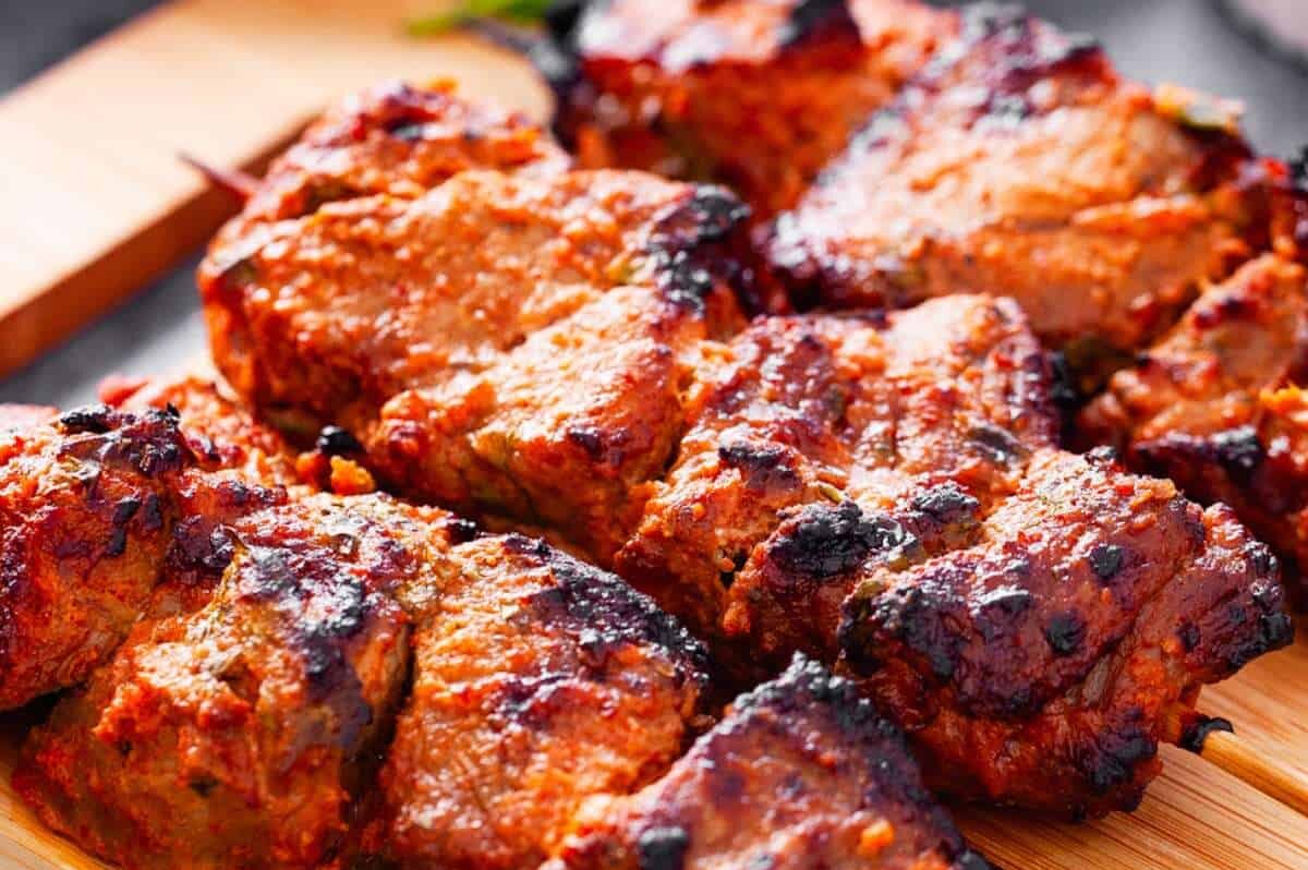 Close-up of grilled, marinated chicken pieces.