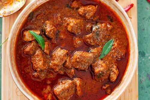 Spicy chicken curry with rich red gravy and fresh green chilies.