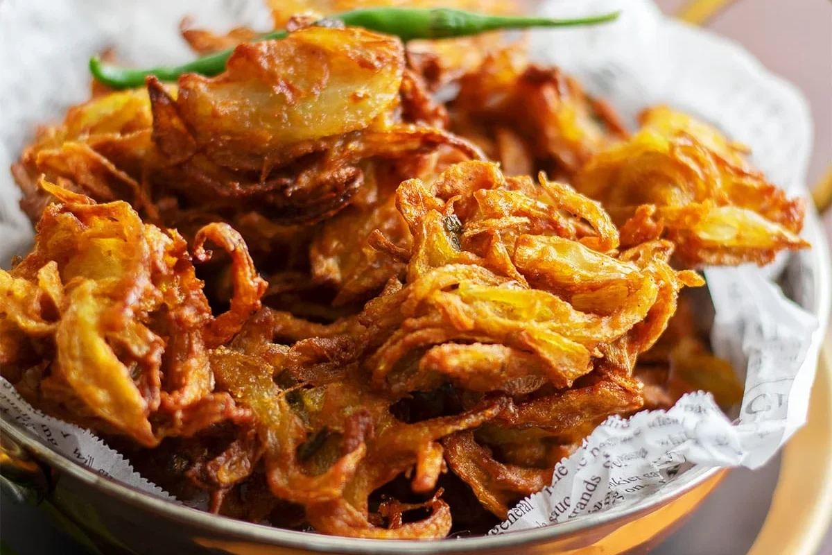 A plate of crispy golden onion bhajis.