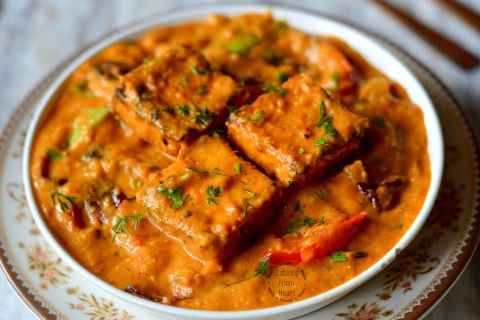 Spicy tofu curry garnished with fresh herbs in a creamy sauce.