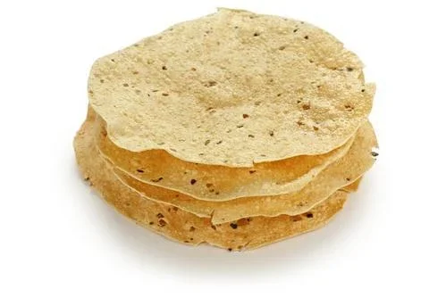 Stack of round, crispy papadums.