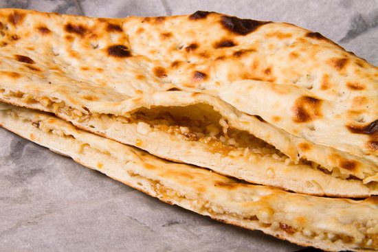 Close-up of stuffed flatbread with a golden crust.