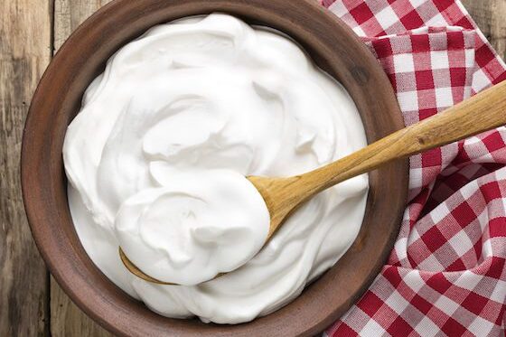 A bowl of fluffy whipped cream with a wooden spoon.