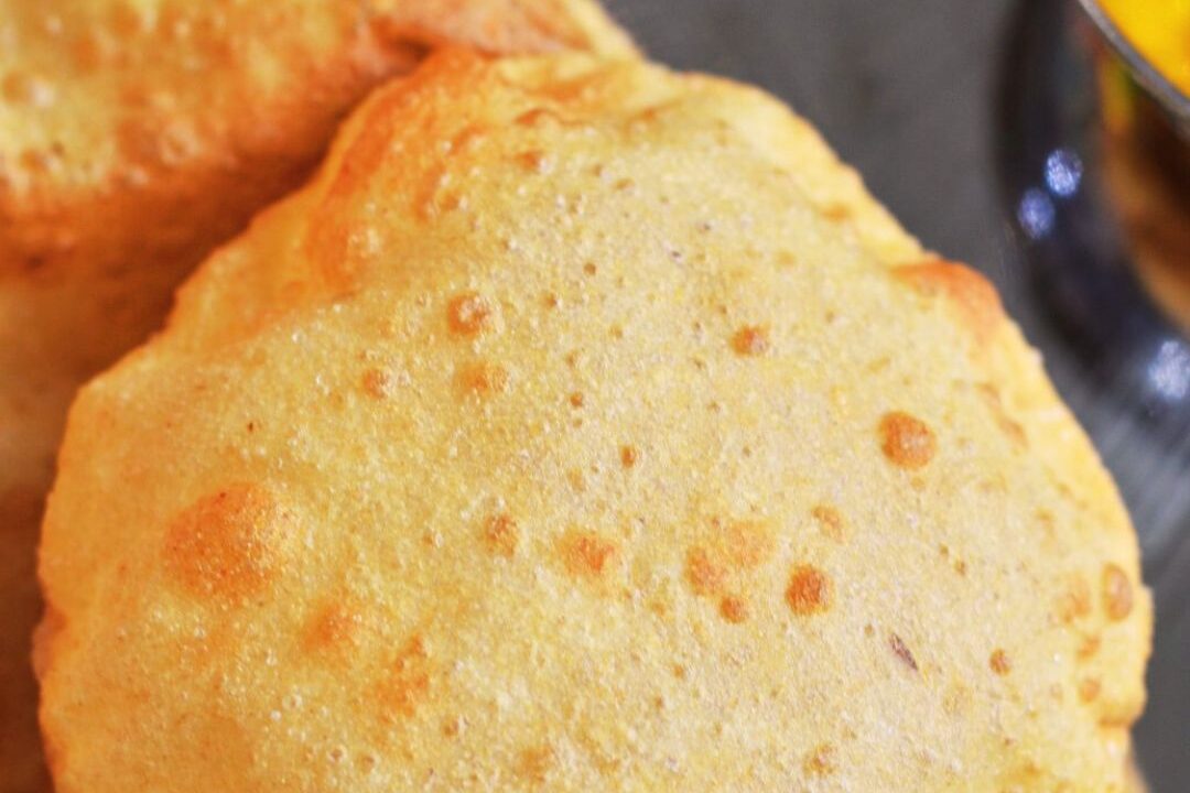 Close-up of a golden, puffed Indian bread called puri.