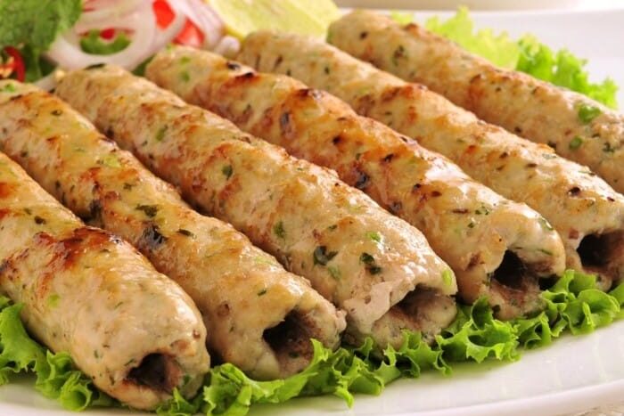 Grilled chicken kebabs served on fresh lettuce.