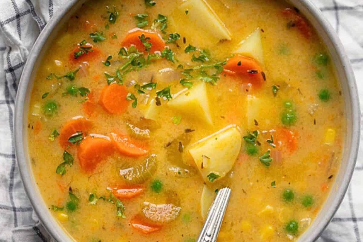 A bowl of hearty vegetable soup with carrots and potatoes.