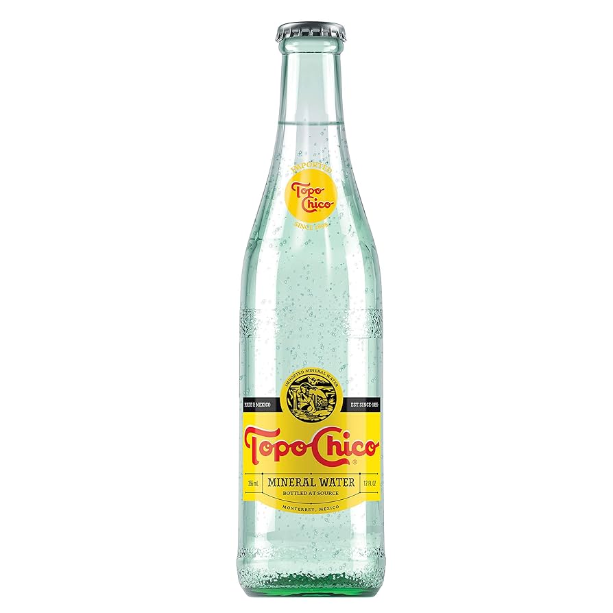 A clear glass bottle of Topo Chico sparkling mineral water.