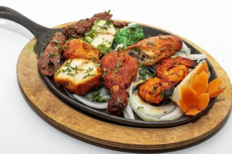 A plate of assorted grilled Indian tandoori meats and paneer.